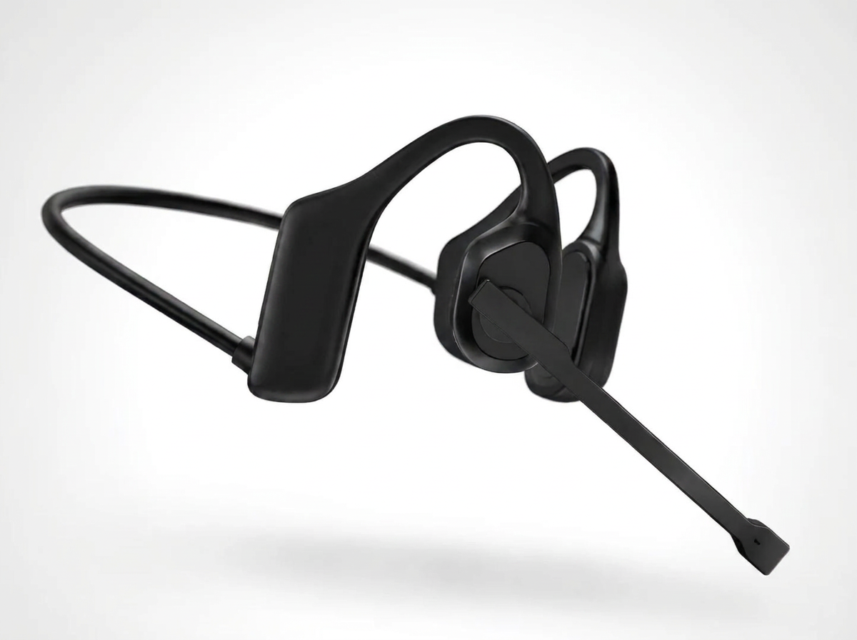 Black bone-style over-ear headphones with an attached boom microphone, shown floating against a clean light gray background.